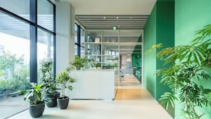 A modern interior with large windows, indoor plants, and a reception desk. - toggle hotel suidobashi TOKYO (Tokyo)