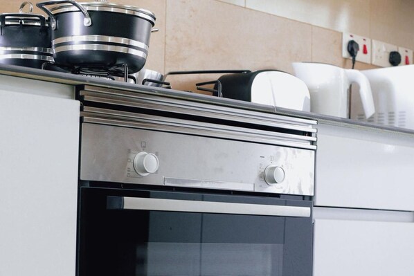 Una cocina con horno empotrado y campana extractora de acero inoxidable.