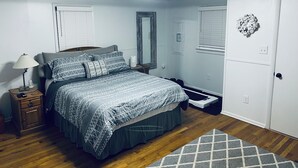 A bedroom with a bed, bedside table, lamp, mirror, and a small rug. - Cannon Cliffside River Retreat-  FREE WIFI (Springfield)