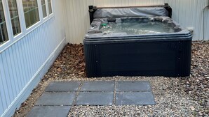 A hot tub in a covered outdoor area with a stone pathway leading to it. - Cannon Cliffside River Retreat-  FREE WIFI (Springfield)