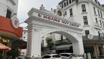 A white building with an ornate archway labeled "Hoang Huy Group".