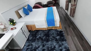Une chambre d’hôtel moderne équipée d’un lit, d’un bureau et d’une armoire.