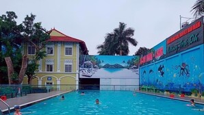 Una piscina con un mural de una playa y palmeras.
