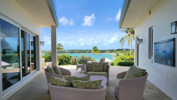 A covered outdoor seating area with wicker furniture and a view of the ocean. - "Gorgeous, 4-bedroom, 4.5-bathroom home with Beautiful Water and Sunset Views!" (George Town, Great Exuma)