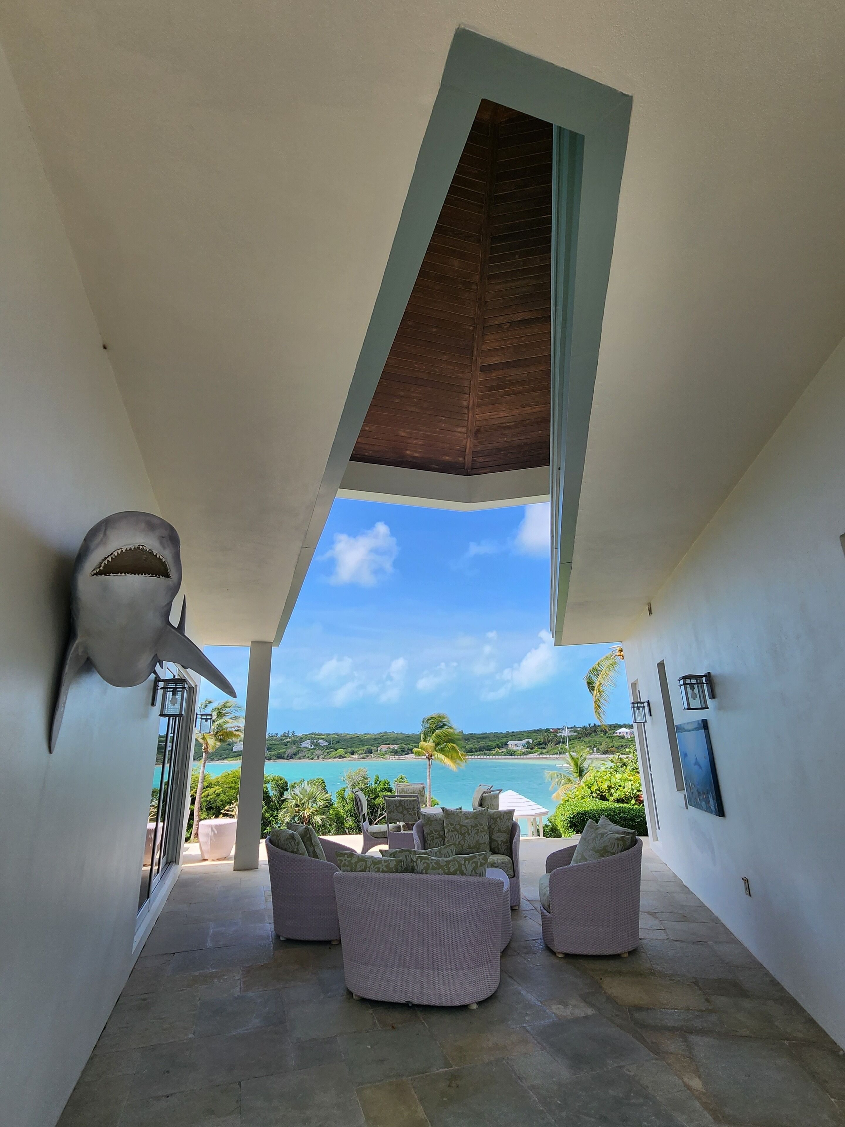 A modern interior with a view of a beach and ocean.