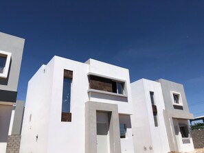 Un bâtiment moderne à la façade blanche et doté de nombreuses fenêtres.