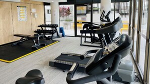 A gym with exercise equipment, a bench, and a treadmill. - SEASIDE ESCAPE@ The Cosmopolitan Unit 10406 (Sunshine Coast)