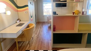 Une pièce comprenant un bureau, une chaise, un lit et un tapis à carreaux.