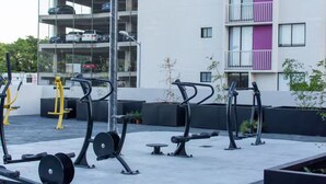 Outdoor gym equipment, a multi-story parking garage, and a building with balconies. - Parques Guadalajara Department Condominium, Central, Comfortable (Guadalajara)