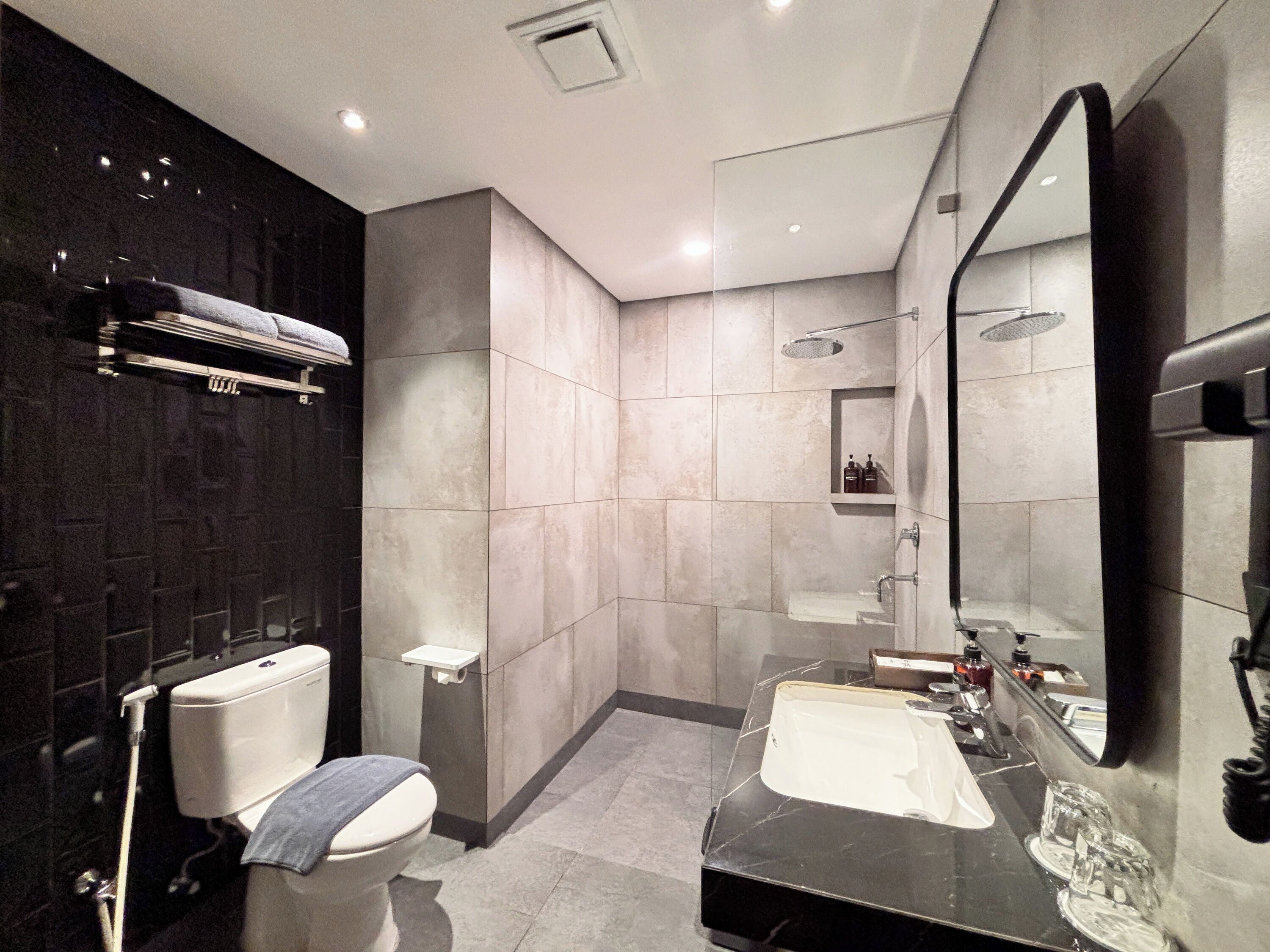 A modern bathroom with a toilet, sink, and shower.