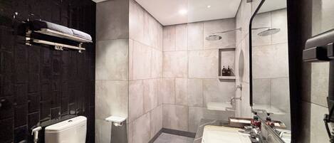 A modern bathroom with a toilet, sink, and shower.
