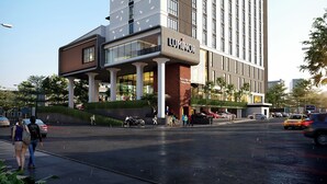 Un hotel moderno con un llamativo letrero 'LUXMINOR', que presenta una estructura de varios pisos con grandes ventanales y un techo plano.