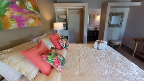 Une chambre d’hôtel avec un lit, une salle de bain et un miroir.