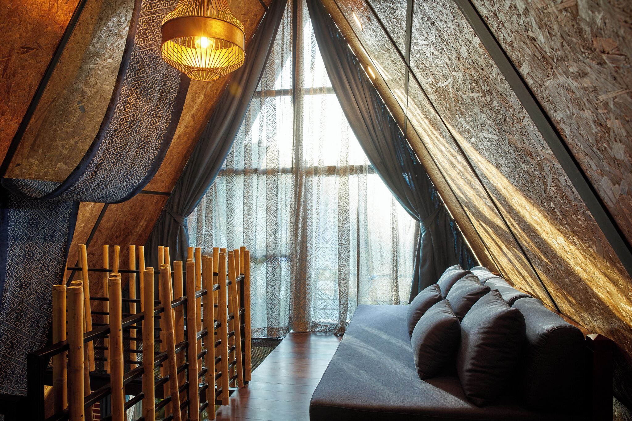 A cozy, wooden interior with a sofa and a bamboo rack.