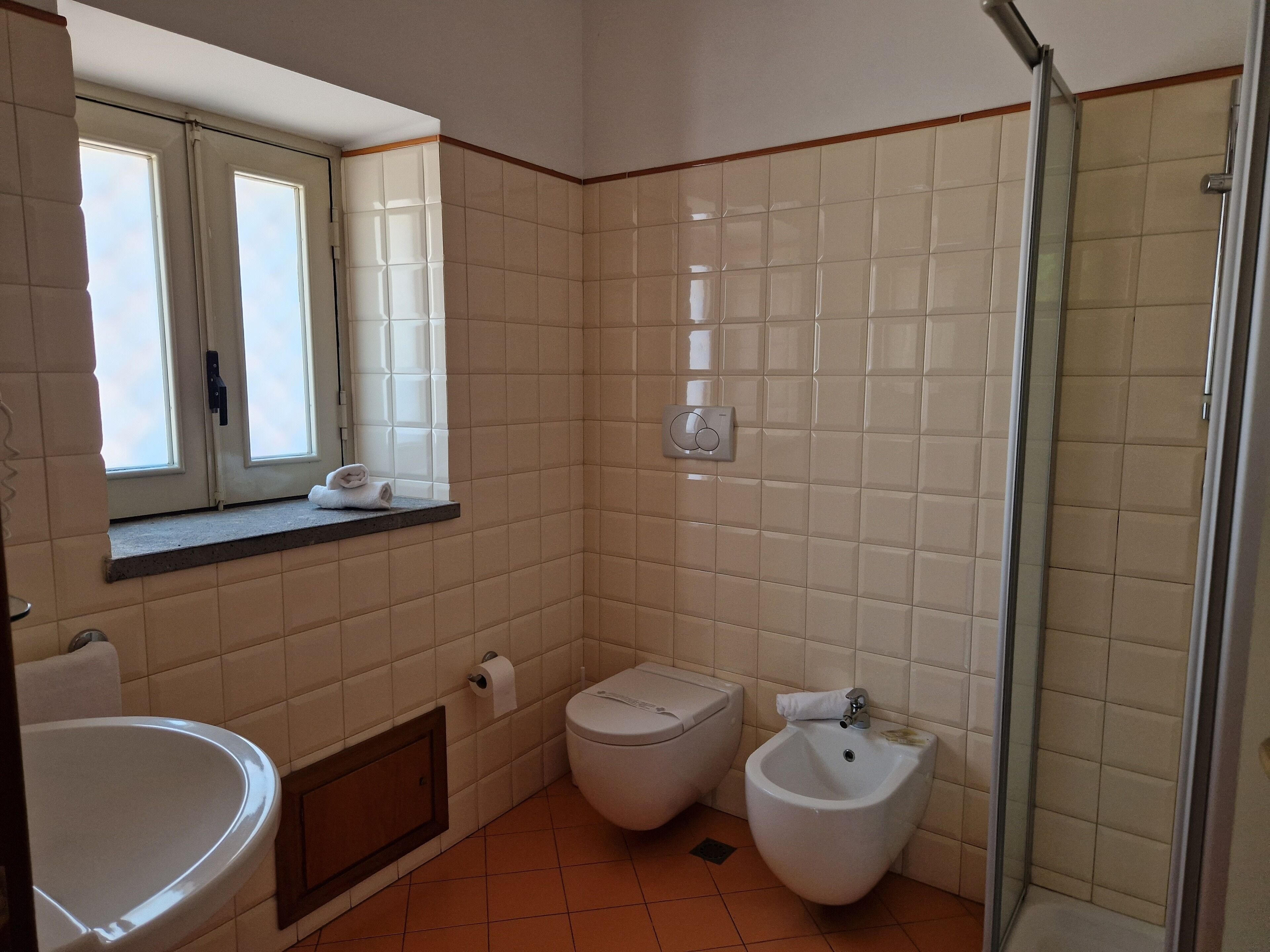 A bathroom with a toilet, bidet, and sink.