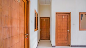 A hallway with wooden doors numbered 4, 5, and 6. - Hotel O Kenari House Syariah (Depok)