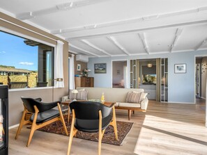 A spacious living area with a large window, a sofa, a coffee table, and a fireplace. - "Hoat" - 300m from the sea by Interhome (Saltum)