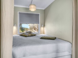 Une chambre à coucher avec un lit, une fenêtre donnant sur un beau paysage et un luminaire suspendu.