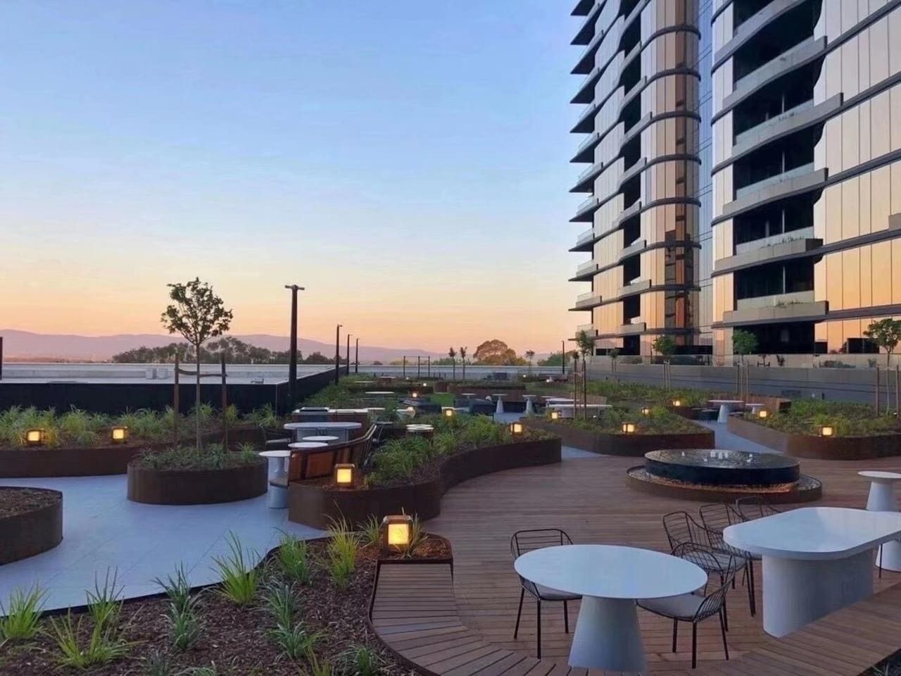A rooftop terrace with outdoor seating and a view of the city skyline.