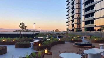 A rooftop terrace with outdoor seating and a view of the city skyline.