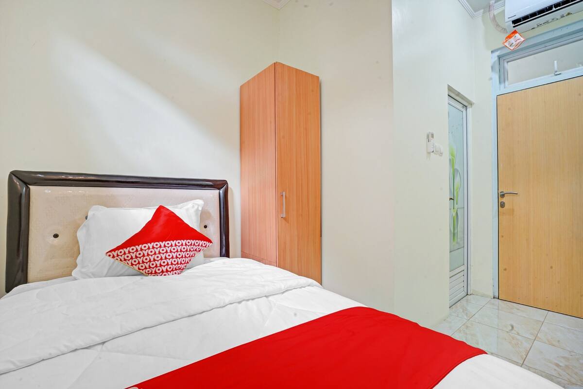 Une chambre à coucher avec un lit, une armoire et une porte.