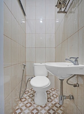 A bathroom with a toilet, sink, and shower. - OYO 90804 Oma Uti Homestay Syariah (Yogyakarta)