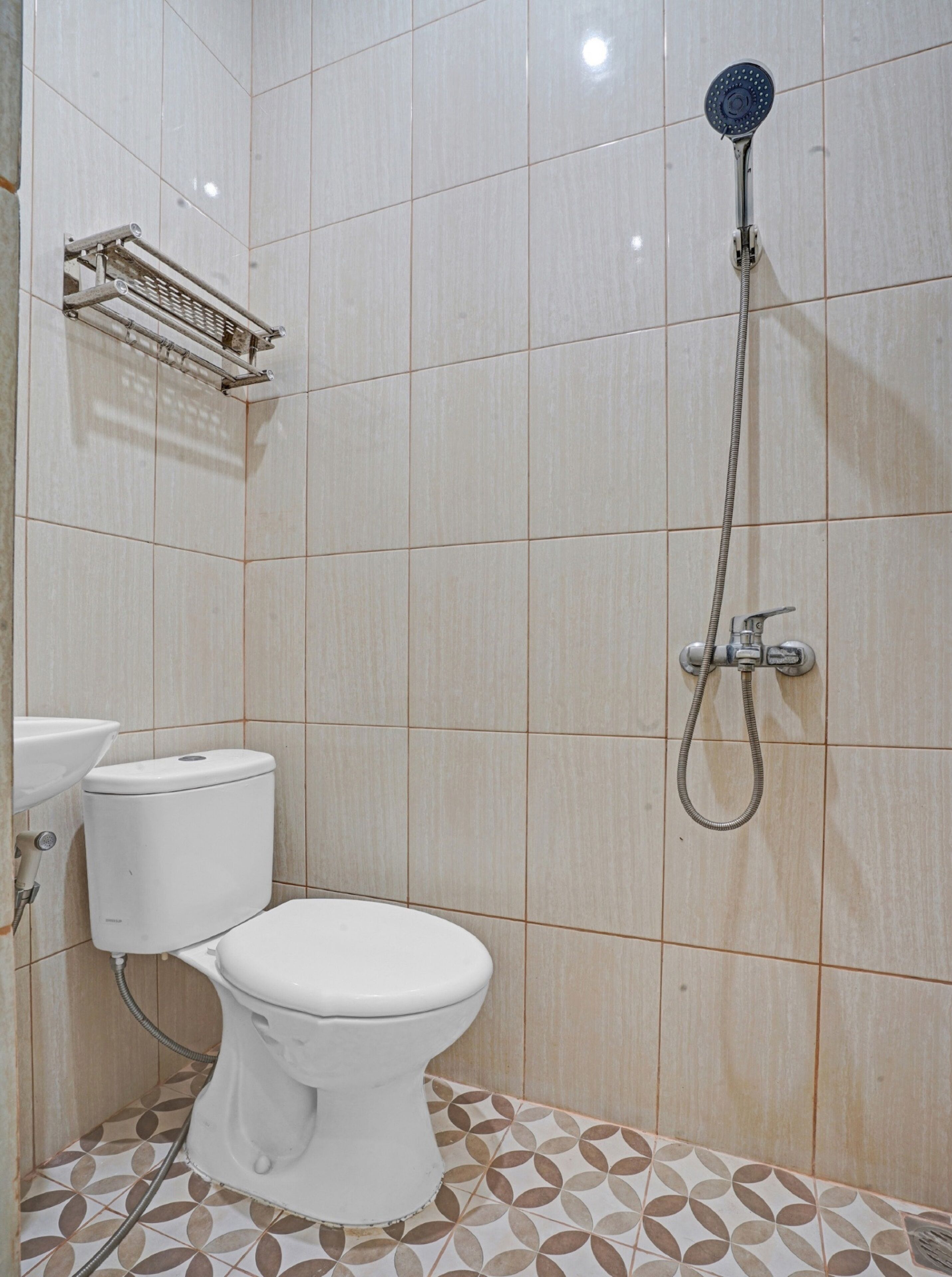 Une petite salle de bain comprenant des toilettes, une douche et un porte-serviettes.