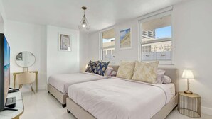 A modern hotel room with two beds, a television, a desk, and a lamp. - 3BR Penthouse with European Flair & Amazing Views (Miami)