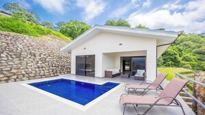 A modern house with a swimming pool, outdoor seating, and a stone wall. - Journeys End-stunning Views In Gated Community (Atenas)