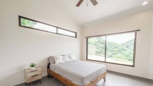 A bedroom with a bed, a nightstand, a window, and a ceiling fan. - Journeys End-stunning Views In Gated Community (Atenas)