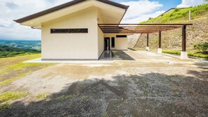 A modern house with a sloped roof, a covered porch, and a view of the countryside. - Journeys End-stunning Views In Gated Community (Atenas)