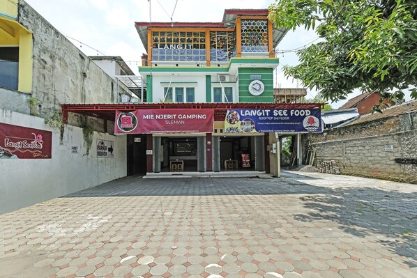 A building with a sign for 'MIE NJERIT CAMPING SLEMAN' and 'LANGIT SEA FOOD' on the ground floor. - Hotel O Dangau Datuk Guesthouse (Sleman)