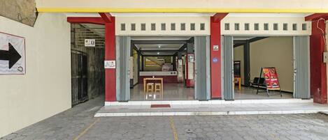 A building entrance with a red roof and hexagonal tiled floor.