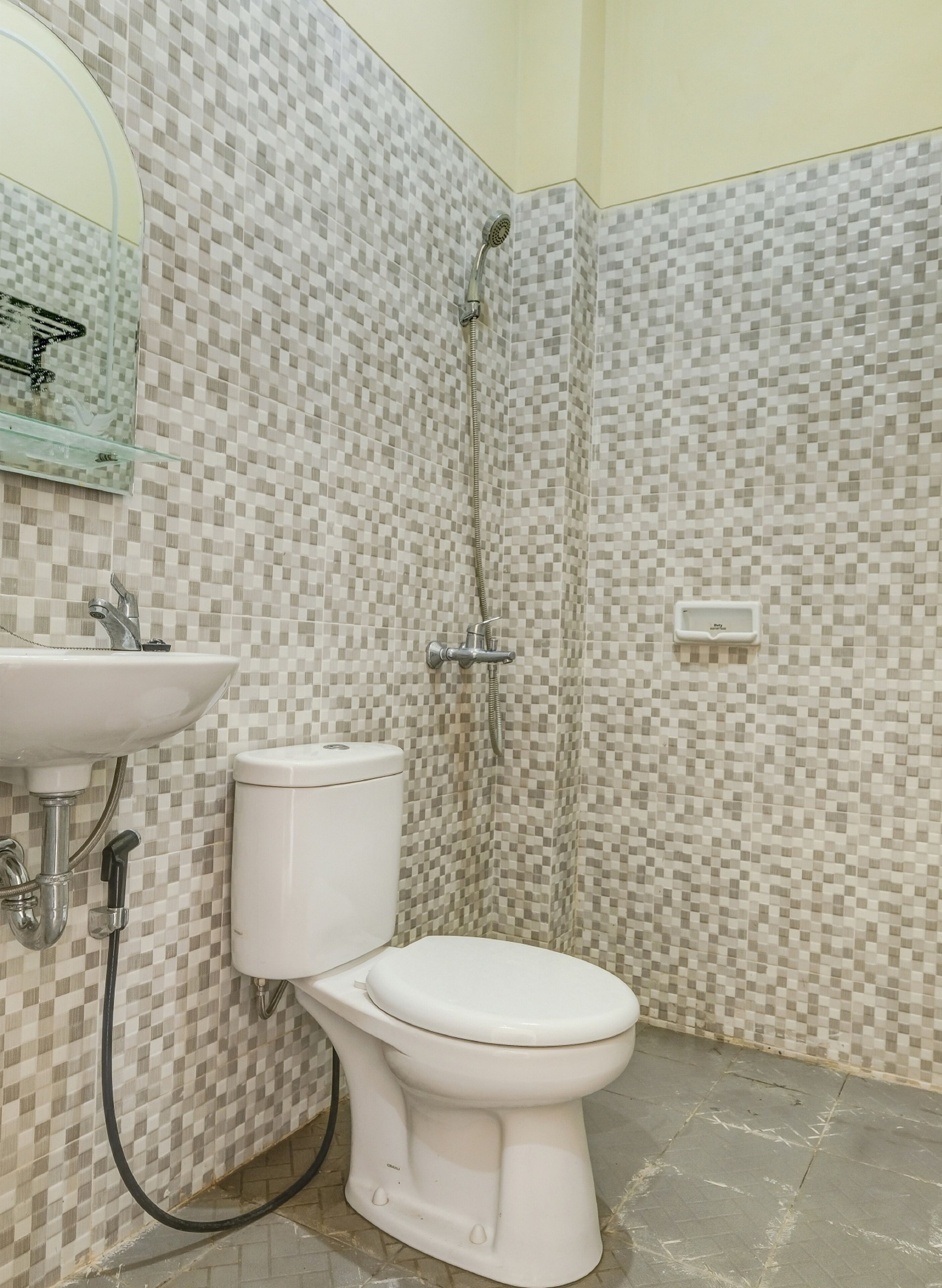 A bathroom with a toilet, sink, and shower.