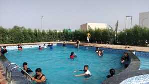 A swimming pool with people in it. - Amazing Fun World By Nexottel (Dwarka)