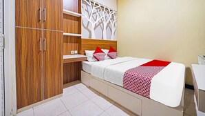 A bedroom with a bed, a wardrobe, and a wall-mounted shelf. - OYO 91342 Tatti Inn Syariah (Depok)