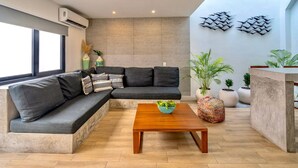 A modern living room with a sectional sofa, a wooden coffee table, and potted plants. - 2 Br Great Located Spacious Amazing Terrace (Tulum)