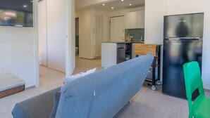 A modern kitchen with a black refrigerator, a wooden cabinet, and a small countertop. - Calm 1BR Apt renovated with terrace and WiFi in Menton (Menton)