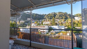 A balcony with a view of a hillside town, metal railings, and a tiled floor. - Calm 1BR Apt renovated with terrace and WiFi in Menton (Menton)
