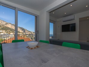 Un espace repas comprenant une table, des chaises et offrant une vue sur un paysage montagneux.