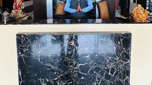 A reception desk with a clock, a chandelier, and a statue. - Hotel Riya Palace (Haldwani)
