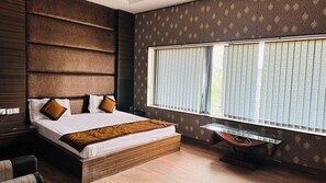 Un dormitorio moderno con una cama grande, una mesita de noche y una ventana con persianas.