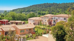 Un quartier résidentiel composé de plusieurs maisons à deux étages, chacune ayant un toit en tuiles et un petit jardin devant.
