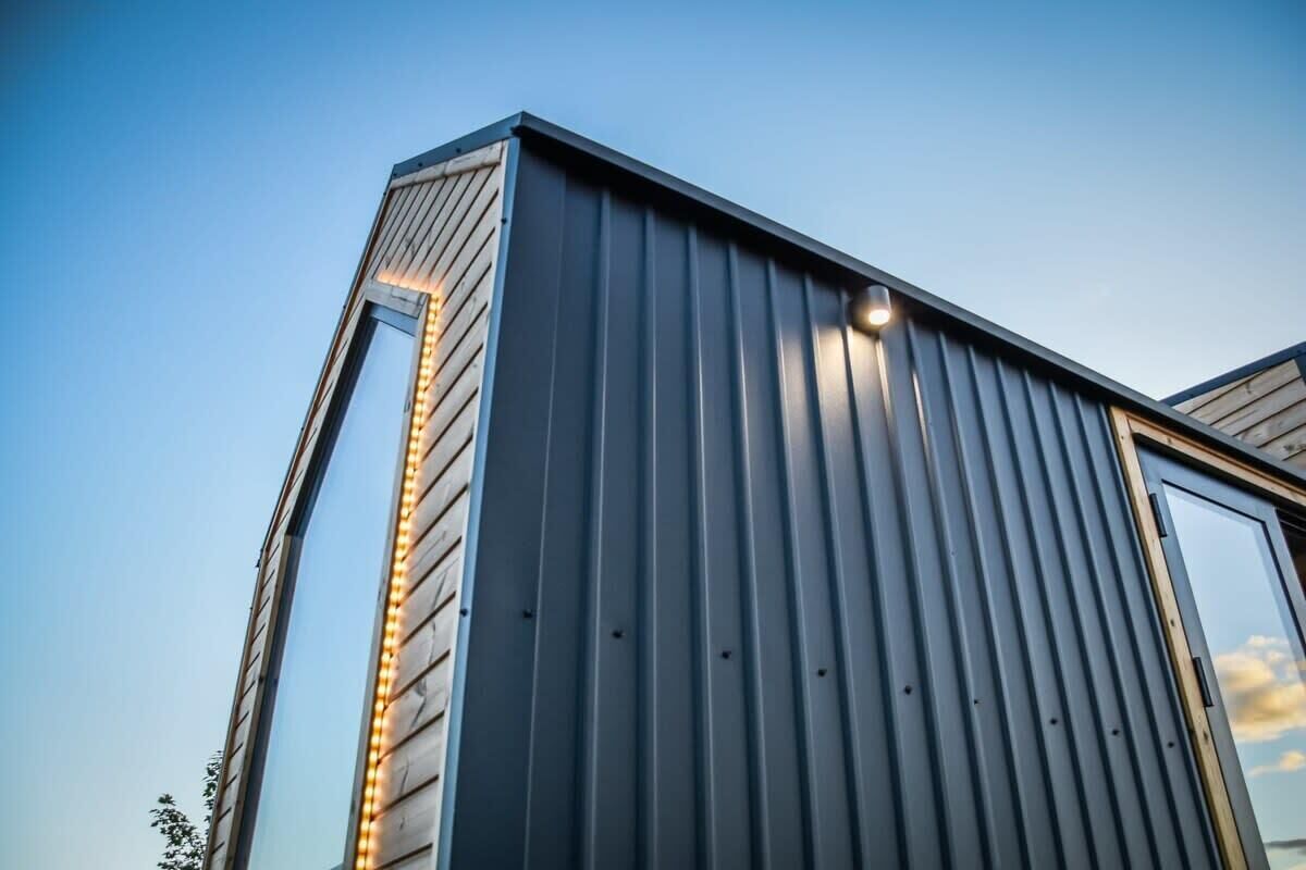 A modern building with a vertical window and a metal exterior.