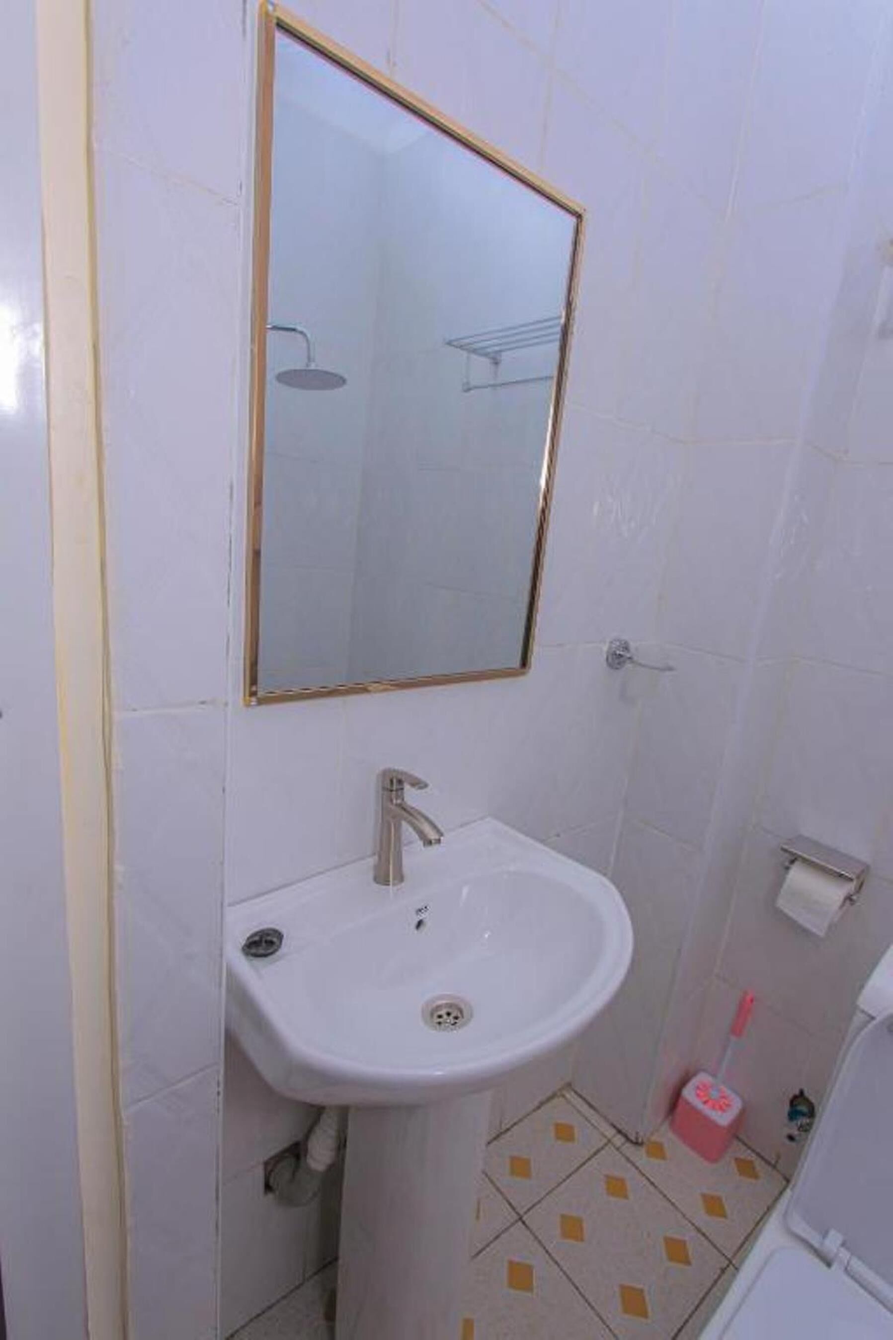 A bathroom with a white sink, a mirror, and a toilet.
