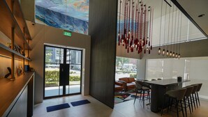 A modern interior with a large table and chairs, a view through glass doors, and a ceiling with hanging lights. - ST Signature Bugis Middle, SHORT OVERNIGHT, 11 hours: 8PM-7AM  (Singapore)