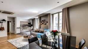 A modern apartment with a living room, dining area, and kitchen. - The magnificent residence in the heart of 8th district- rue de la Boetie (Paris)