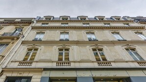 A multi-story building with classical architecture, featuring symmetrical windows and decorative moldings. - The magnificent residence in the heart of 8th district- rue de la Boetie (Paris)