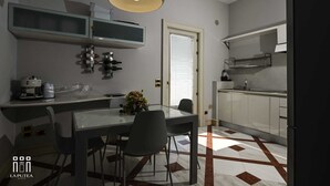 A compact kitchen with a dining area, a built-in oven, and a coffee machine. - La putea suite (Lecce)