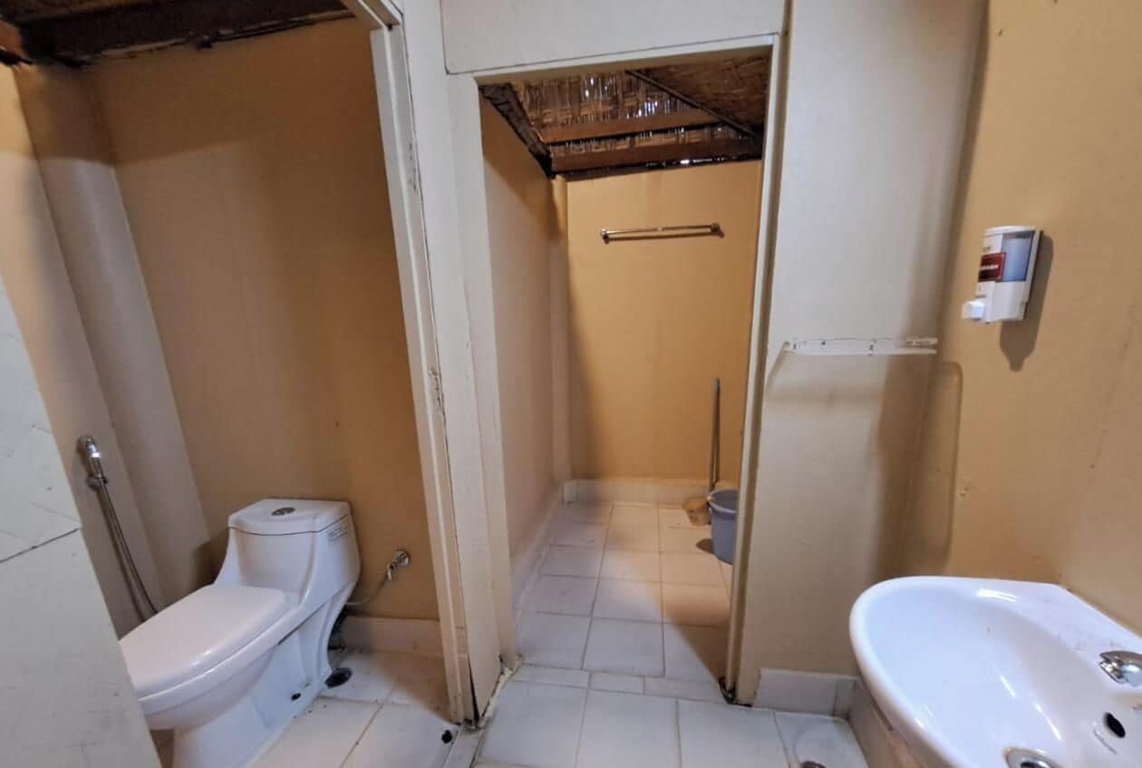 Un baño pequeño con inodoro, lavamanos y zona de ducha.